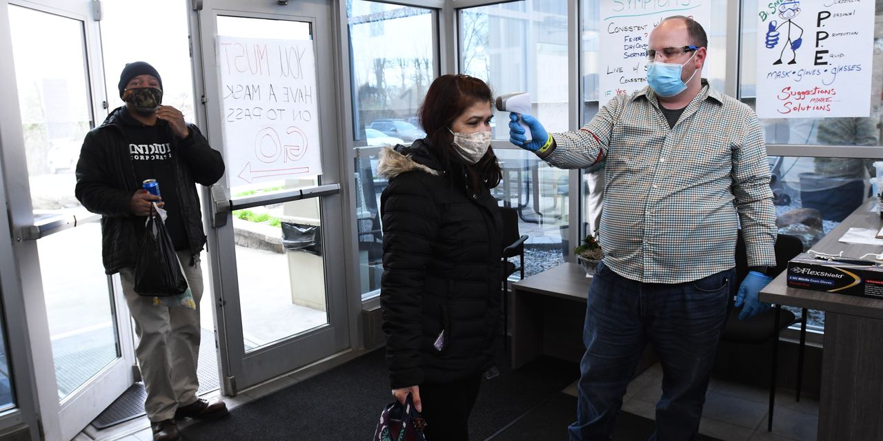 Indium employees wearing PPE and having temperature checked before entering work.