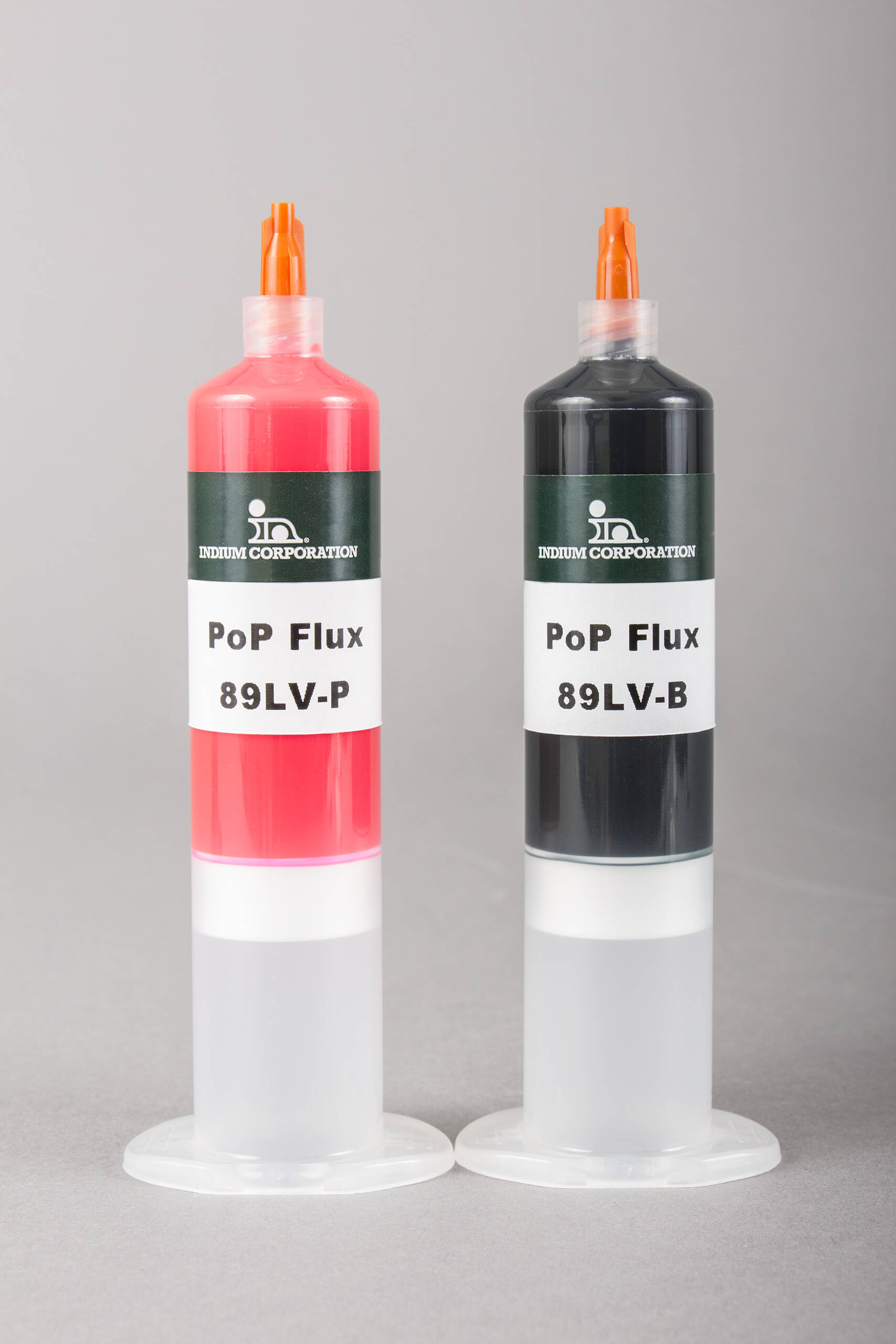 Two syringes labeled "PoP Flux 89LV-P" and "89LV-B," with pop flux's signature red and black caps, stand upright on a gray background.