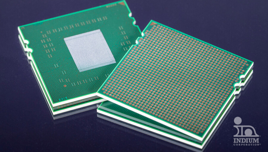 Two green microprocessor chips with one showing a grid of pins and the other displaying a central metallic square on a dark surface.