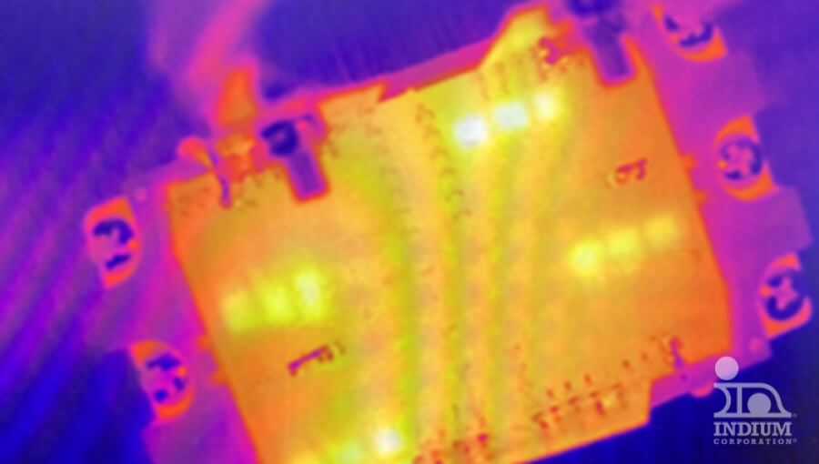 A thermal image of an electronic circuit board showing areas of varying heat, with bright orange and yellow indicating hot spots and cooler areas in purple and blue.