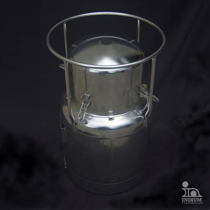 A stainless steel milk can with a secure lid and handles, placed against a dark background.
