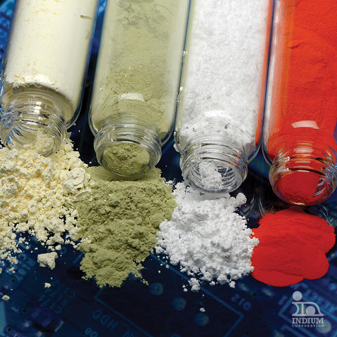Four glass vials lie on their sides, spilling different colored powders: ivory, pale green, white, and bright red, against a dark background.