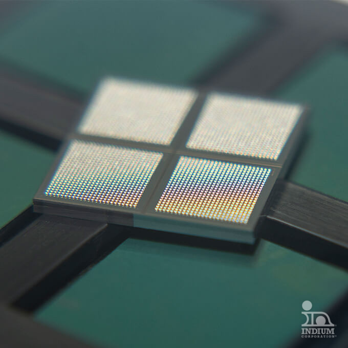 Close-up of a square semiconductor chip with four subdivided sections on a green and black background.