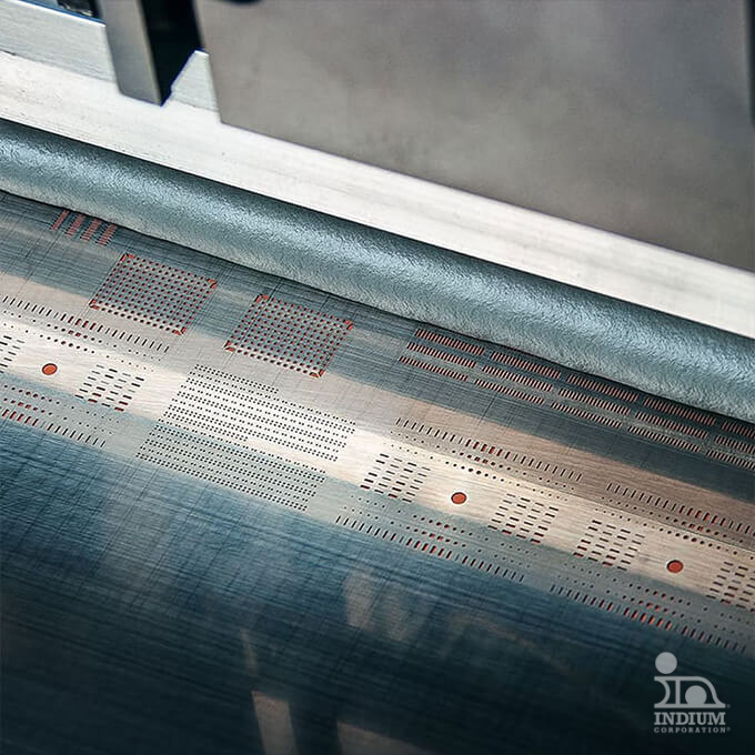 Close-up of a sheet metal stamping process, showing intricate patterns and holes being created on the surface.
