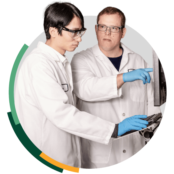 Two Indium engineers look at results on a computer screen, illustrating Indium's ability to connect directly with their clients engineers.