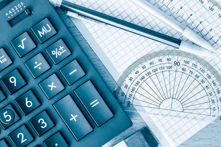 Calculator, pen, protractor, eraser, and graph paper arranged on a desk for math or geometry work.