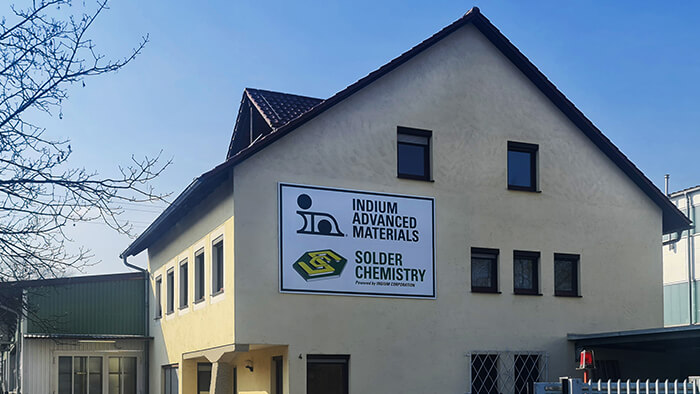 A building with signs for "Indium Advanced Materials" and "Solder Chemistry" on its facade.